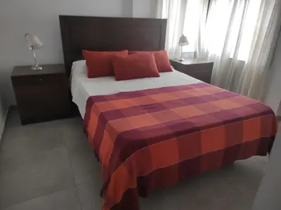 a bedroom with a large bed with red pillows at Departamento Ripozi Centro muy luminoso in Cordoba