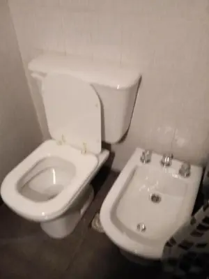 a bathroom with a white toilet and a sink at Departamento Ripozi Centro muy luminoso in Cordoba