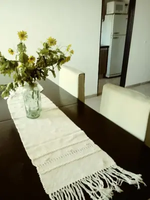a vase with flowers on a table with a mirror at Departamento Ripozi Centro muy luminoso in Cordoba