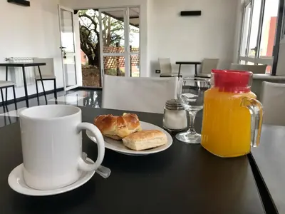 a cup of coffee and a plate of food and orange juice at Alondra Apart in Villa Cura Brochero