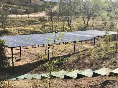 a wooden platform with a solar panel on top of a field at Alondra Apart in Villa Cura Brochero