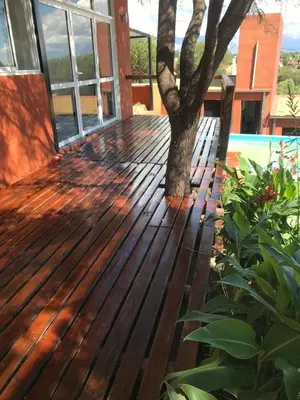 a wooden deck with a tree on a house at Alondra Apart in Villa Cura Brochero