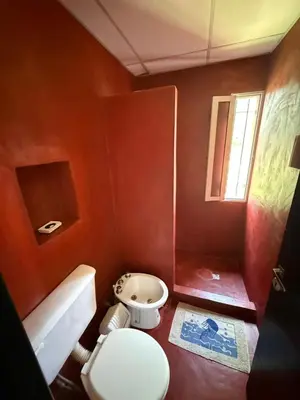 a red bathroom with a toilet and a sink at Alondra Apart in Villa Cura Brochero