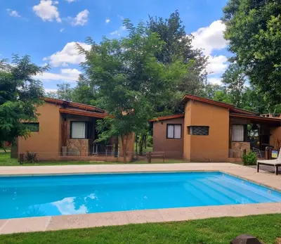 a house with a swimming pool in the yard at CABAÑAS SUKHA in Santa Rosa de Calamuchita