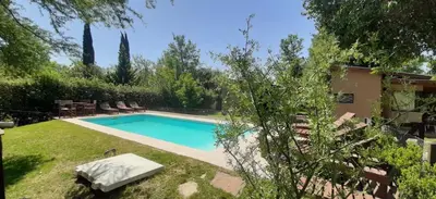 a swimming pool in the yard of a house at CABAÑAS SUKHA in Santa Rosa de Calamuchita