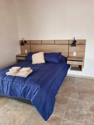 a bedroom with a blue bed with blue sheets at CABAÑAS SUKHA in Santa Rosa de Calamuchita