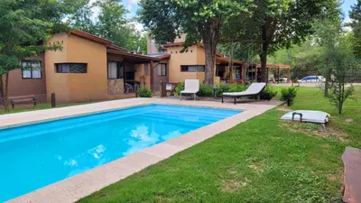 a swimming pool in the yard of a house at CABAÑAS SUKHA in Santa Rosa de Calamuchita
