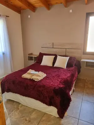 a bedroom with a bed with two towels on it at CABAÑAS SUKHA in Santa Rosa de Calamuchita