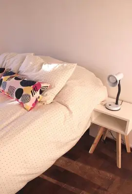a bedroom with a bed with a lamp and a table at Depa Patio Olmos in Cordoba