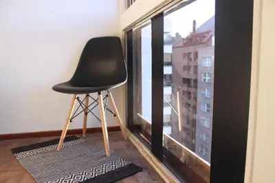 a black chair sitting in front of a window at Depa Patio Olmos in Cordoba