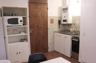 a kitchen with white cabinets and a microwave at Depa Patio Olmos in Cordoba
