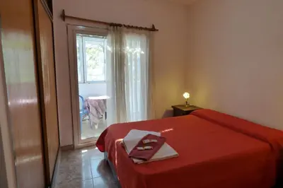 a bedroom with a red bed and a window at Departamento Luminoso y Ventilado Centro Viejo in Villa Carlos Paz