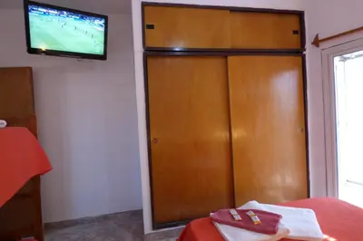 a room with a wooden cabinet with a television on it at Departamento Luminoso y Ventilado Centro Viejo in Villa Carlos Paz
