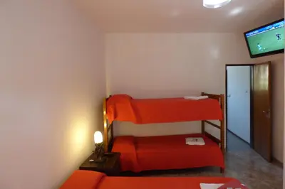 a room with a red bunk bed and a tv at Departamento Luminoso y Ventilado Centro Viejo in Villa Carlos Paz
