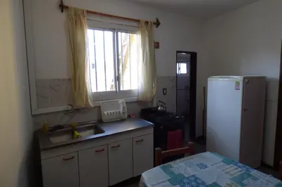 a kitchen with a sink and a refrigerator and a window at Departamento Luminoso y Ventilado Centro Viejo in Villa Carlos Paz