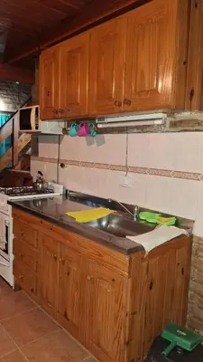 a kitchen with wooden cabinets and a sink at Los Teros in Tanti