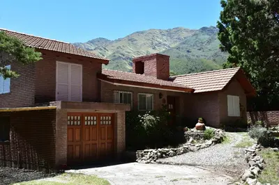 a brick house with a garage and mountains in the background at Chalet Tornasol in El Rincón