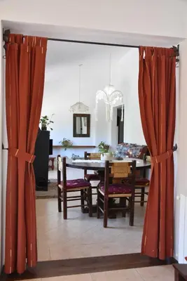 a dining room with red curtains and a table and chairs at Chalet Tornasol in El Rincón