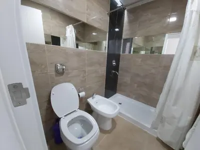 a bathroom with a white toilet and a shower at Edificio Leonardo, 5to piso in Villa Carlos Paz