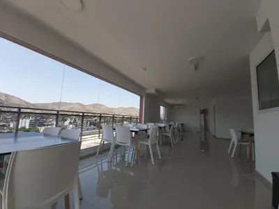 a dining room with tables and chairs and a large window at Edificio Leonardo, 5to piso in Villa Carlos Paz