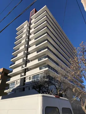 a white van parked in front of a tall building at Edificio Leonardo, 5to piso in Villa Carlos Paz
