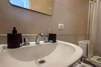a bathroom with a sink and a mirror and a toilet at Apartamento Alta Córdoba con piscina! in Cordoba
