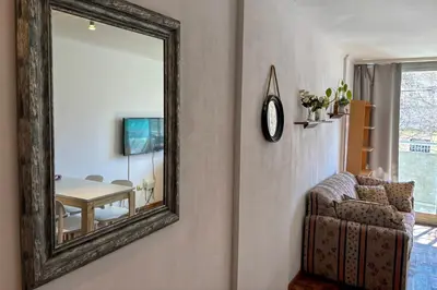 a mirror on a wall with a chair and a table at Apartamento Alta Córdoba con piscina! in Cordoba