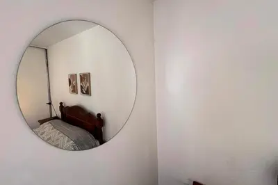 a mirror on a wall with a bed in a room at Apartamento Alta Córdoba con piscina! in Cordoba