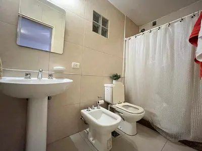 a white bathroom with a sink and a toilet at Apartamento Alta Córdoba con piscina! in Cordoba