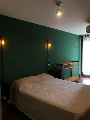 a bedroom with a green wall and a bed at 