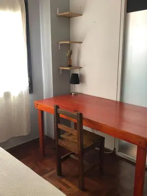 a wooden desk with a chair next to a window at 