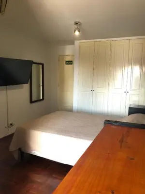 a bedroom with a large white bed and a television at 