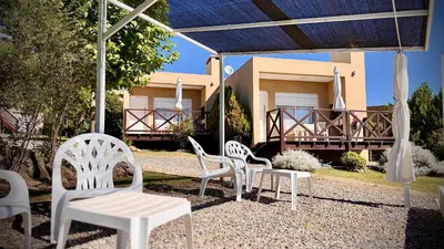 a group of white chairs sitting in front of a house at ARROYO SUITE HOUSE in Mina Clavero