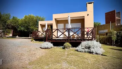 a house with a large wooden deck in front of it at ARROYO SUITE HOUSE in Mina Clavero