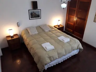 a bedroom with a large bed with two towels on it at Las Verbenas Hotel in La Cumbrecita