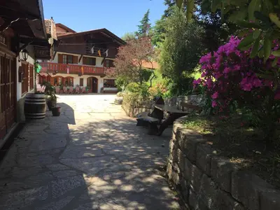 a stone pathway with benches and flowers in front of a building at Las Verbenas Hotel in La Cumbrecita