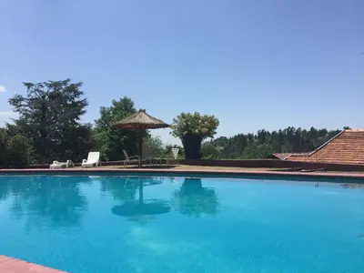 a large blue swimming pool with a gazebo at Las Verbenas Hotel in La Cumbrecita