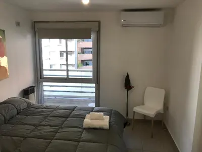 a bedroom with a bed and a chair and a window at Jardines del Boulevard 2 in Cordoba