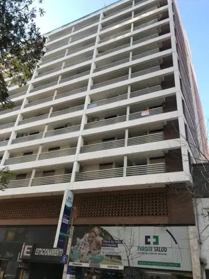 a tall white apartment building with a billboard in front of it at Jardines del Boulevard 2 in Cordoba