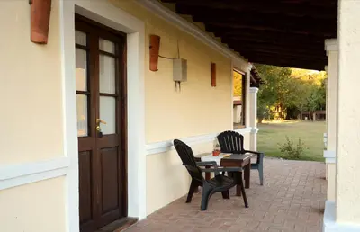 two chairs and a table on the side of a building at La Catalina Suites de Campo in Nono