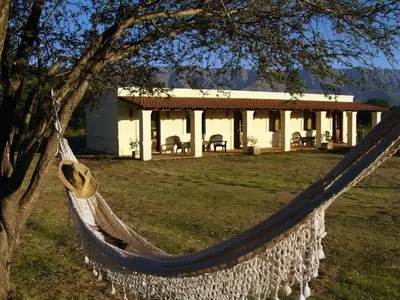 a hammock in front of a house at La Catalina Suites de Campo in Nono