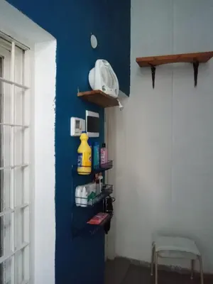 a room with a blue wall with a shelf and aether at RAIZ DEL CIELO, entre 2 jardines de ensueño in Cordoba