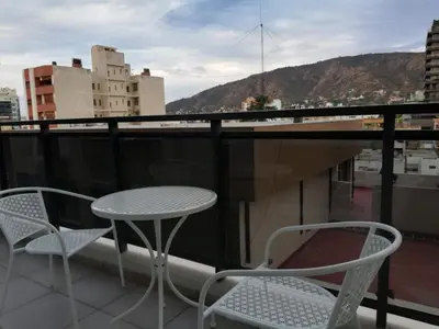 a table and chairs on a balcony with a view at DEPARTAMENTO Edificio LEONARDO in Villa Carlos Paz