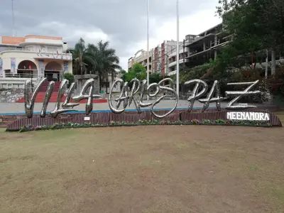 a sign with graffiti on a fence in a city at DEPARTAMENTO Edificio LEONARDO in Villa Carlos Paz