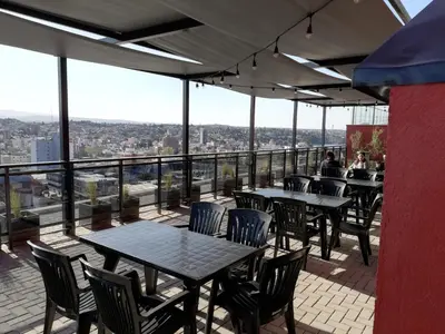 a restaurant with tables and chairs on a balcony at DEPARTAMENTO Edificio LEONARDO in Villa Carlos Paz