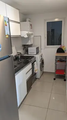 a small kitchen with a refrigerator and a microwave at DEPARTAMENTO Edificio LEONARDO in Villa Carlos Paz