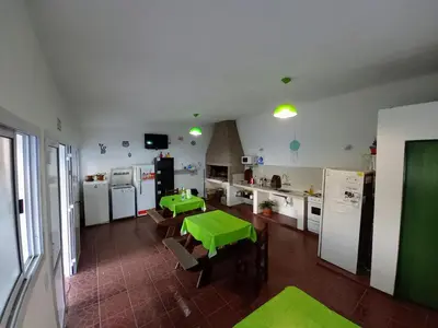a kitchen with two green tables in a room at Hostal El Trébol - Tanti in Tanti