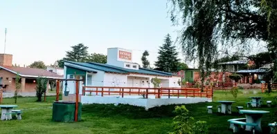 a building with picnic tables in front of it at Hostal El Trébol - Tanti in Tanti