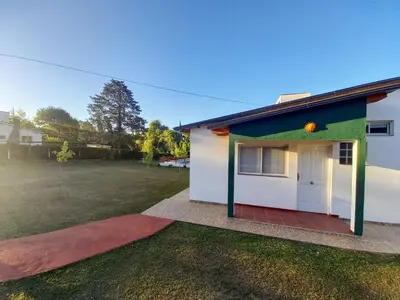 a small house with a green and white facade at Hostal El Trébol - Tanti in Tanti