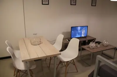 a table with white chairs and a computer on it at Dpto Downtown Nueva Córdoba, la mejor ubicación!! Sin Gastos adicionales - Cochera opcional in Cordoba